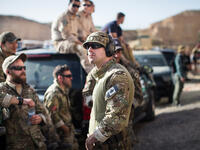 Members of the American and Canadian teams cheer together and watch the remaining teams compete in the "Top Gun" event at the seventh annual Warrior Competition. “It’s a little surreal,” one American soldier said. “You never know what guys you see here today might be fighting each other in a couple of years.”