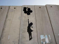 Visitors to his website are reminded that Israel’s 425-mile-long West Bank barrier, which separates Israel from Palestine is considered illegal by the United Nations. Banksy says the wall is "the ultimate activity holiday destination for graffiti writers.” Up, up and away!
