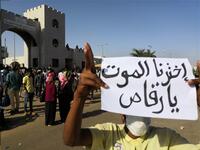 A Sudanese protester holds a placard during a demonstration in front of the military headquarters in the capital Khartoum on April 9, 2019. The writing on the placard reads in Arabic : "We have chosen death, hey dancer", referring to the president. 
STRINGER / AFP