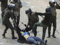 This 'blue-bra'd' girl is the iconic image for Egypt's post-revolution. Her graphic ordeal stands for indiscriminate violence to Muslim & Christian alike at the hands of the army. This veiled protestor was strewn in an undignified state when soldiers rough-handled her. Ripped apart at the seams, she diverted our eyes from the burning Churches.
