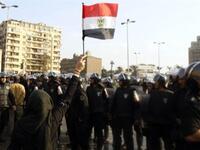 An Egyptian demonstrator holds up her national flag near the Egyptian police.