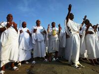 The Hajjis or pilgrims wear simple white clothes called Ihram: Male Muslims put on 2 clean, unstitched, white,
pieces of cloth. One sheet is wrapped around the lower part of the body and the other sheet around the upper body; the 
head should not be covered. Women may perform pilgrimage in the cloths they are wearing, without the face veil.
