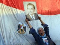A supporter of ousted Egyptian President Hosni Mubarak holds his picture outside the police academy where Mubarak's trial is held on the outskirt of Cairo.