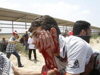 Gaza Guard: Palestinians carry away a wounded man as Israeli troops opened fire during on a massive march heading towards the Erez border crossing in the northern Gaza Strip. 45 injuries counted. 