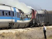 An Israeli policeman stands next to a burning train coach near Kibbutz Shfaim.