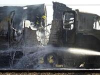 Israeli fire fighters spray water to extinguish the flames of a burning train coach.