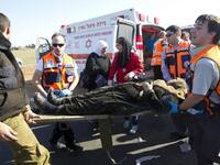 A wounded Arab Israeli woman is evacuated from a burning train coach by paramedics near Kibbutz Shfaim.