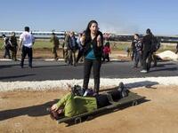 An Israeli woman reacts as she stands next to a wounded woman waiting to be evacuated on a stretcher at the scene of a train fire.