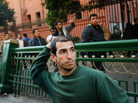 Anti-Mubarak protesters throws rocks at pro-government supporters during a clash between pro - and anti - Mubarak protesters.