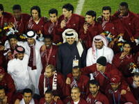 Sheikh Tamim Bin Hamad Al-Thani celebrates with the Qatar team after the gold medal match between Qatar and Iraq (Getty)