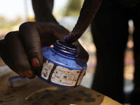 A woman places her finger in blue ink after voting.
