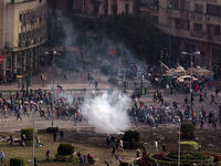 Protesters flee a volley tear gas in Tarhir Square.