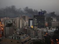Smoke billows up into the late evening sky.
