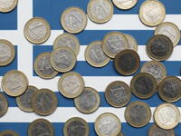 Euro coins atop a Greek flag