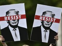A protestor holds placards prior to the Scotland United Against Trump march through the streets of Edinburgh, Scotland on July 14, 2018, on the third day of US President Donald Trump's four-day UK visit. (NEIL HANNA / AFP)