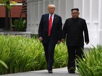 North Korea's leader Kim Jong Un (R) walks with US President Donald Trump (L) during a break in talks at their historic US-North Korea summit, at the Capella Hotel on Sentosa island in Singapore on June 12, 2018. (SAUL LOEB / AFP)