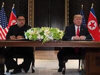 US President Donald Trump (R) speaks while seated with North Korea's leader Kim Jong Un (L) at a signing ceremony during their historic US-North Korea summit, at the Capella Hotel on Sentosa island in Singapore on June 12, 2018. (SAUL LOEB / AFP)