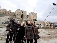 سيلفي حلب المنكوبة
التقطت مجموعة من النساء صور "سيلفي" من أمام القلعة التاريخية الموجودة داخل مدينة حلب، وسط ركام المباني والسيارات المدمرة.