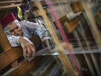 Abdelkader Ouazzani, the last of Morocco's brocade master weavers, displays tapestry at his workshop in the old city of Fez on April 10, 2019. His skilfull hands intricately create shimmering silk fabrics, enhanced with gold or silver thread, for bridal jewellery, designer creations or high-end furnishings. FADEL SENNA / AFP