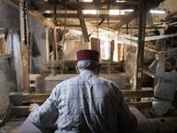 Abdelkader Ouazzani, the last of Morocco's brocade master weavers, displays tapestry at his workshop in the old city of Fez on April 10, 2019. His skilfull hands intricately create shimmering silk fabrics, enhanced with gold or silver thread, for bridal jewellery, designer creations or high-end furnishings. FADEL SENNA / AFP