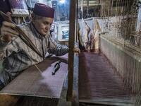 Abdelkader Ouazzani, the last of Morocco's brocade master weavers, displays tapestry at his workshop in the old city of Fez on April 10, 2019. His skilfull hands intricately create shimmering silk fabrics, enhanced with gold or silver thread, for bridal jewellery, designer creations or high-end furnishings. FADEL SENNA / AFP