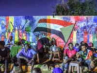 Sudanese protesters sit in front of a recently painted mural during a demonstration near the army headquarters in the capital Khartoum  OZAN KOSE / AFP