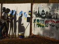 Sudanese protesters paint a graffiti during a "million-strong" march outside the army headquarters in the capital Khartoum. ASHRAF SHAZLY / AFP