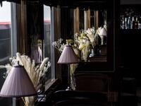 This picture taken on May 13, 2019 shows table lamps and flowers adorning the dining car of a restored carriage of an Orient Express train displayed at the Gare de l'Est train station in Paris.  Christophe ARCHAMBAULT / AFP