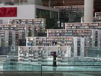 A woman chooses books at the Qatar National Library in the capital Doha.  KARIM JAAFAR / AFP