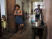 Willy, Jessica and a child, inhabitants of the roca Agostinho Neto, an abandoned cocoa plantation of Sao Tome and Principe, wait in a hall, of the hospital of the roca on May 12, 2019.  Alexis HUGUET / AFP