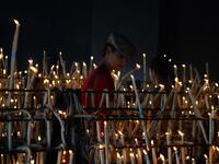 A pilgrim lights a candle at the church of the village of El Rocio.  CRISTINA QUICLER / AFP