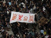 People carry a banner reading "Make love no shoot" in reference to police firing on protesters on June 12, as thousands of protesters dressed in black take part in a new rally against a controversial extradition law proposal in Hong Kong  Dale DE LA REY / AFP