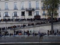 People look at the fire engulfing the Notre-Dame Cathedral in central Paris from the quai de la Tournelle on the banks of the Seine river on April 15, 2019. Geoffroy VAN DER HASSELT / AFP