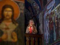 A North Macedonian Orthodox Christian woman holds candles as she takes part in midnight Easter services at the Kalishta Monastery, in the village of Kalishta near Struga, on April 27, 2019.  Robert ATANASOVSKI / AFP