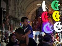 Palestinians walk past shops decorated ahead of the Muslim holy fasting month of Ramadan, in Jerusalem's old city on May 2, 2019.  AHMAD GHARABLI / AFP