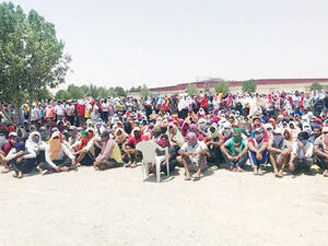 The Asian workers sitting in the open in protest against not receiving salaries for many months.