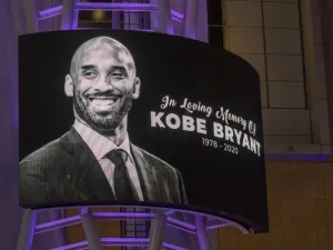 Memorial signage hangs near people mourning for former NBA star Kobe Bryant, who was killed in a helicopter crash in Calabasas, California.