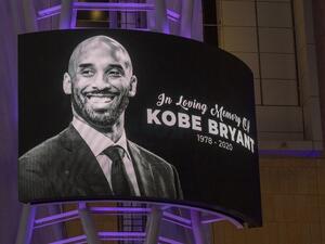 Memorial signage hangs near people mourning for former NBA star Kobe Bryant, who was killed in a helicopter crash in Calabasas, California.
