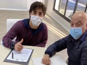 Brazilian teenager Erik Jorgens de Menezes (left) signs the contract. - (Al Ain FC Twitter)