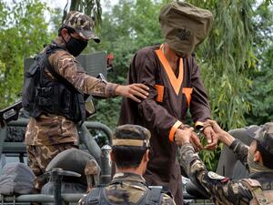 Forces with Afghanistan's National Directorate of Security (NDS) escort an alleged militant as Taliban and Islamic State (IS) fighters are presented to the media in Jalalabad on May 23, 2019. (AFP/ File Photo)