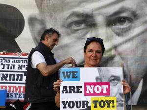 A woman holds a banner as Israeli opposition parties' supporters attend a rally against Prime Minister Benjamin Netanyahu on May 25, 2019 in the coastal city of Tel Aviv. (JACK GUEZ / AFP)