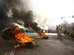 A Sudanese protester walks past burning tyres as military forces tried to disperse the sit-in outside Khartoum's army headquarters on June 3, 2019. (AFP/ File)