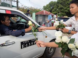 Buddhists give white roses to Muslims as they attend prayers during Eid al-Fitr at Than Lyin township on the outskirts of Yangon on June 5, 2019. (AFP/ File)