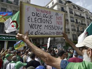 An Algerian protester holds a banner reading "your mission is dismissal" during a demonstration in the capital Algiers on June 7, 2019. Interim Algerian president Abdelkader Bensalah on June 6 called for "dialogue" after the authorities ruled out holding a planned election on July 4. (RYAD KRAMDI / AFP)
