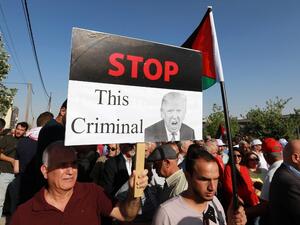 A protester holds an anti-Donald Trump sign as he marches with others during the "March of Anger" demonstration leading to the US embassy headquarters in the Jordanian capital Amman on June 21, 2019, against US President Donald Trump's "Deal of the Century" and the US-led Middle East economic conference in Bahrain.  (Khalil MAZRAAWI / AFP)