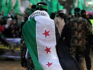 احد قادة القسام يغطي نفسه بعلم الثورة السورية في مسيرة للحركة في غزة 