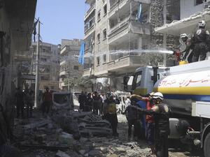 Members of the Syrian Civil Defence (White Helmets) extinguish a fire at the site of a reported air strike on the town of Ariha, in the south of Syria's Idlib province on July 28, 2019. (Omar HAJ KADOUR / AFP)