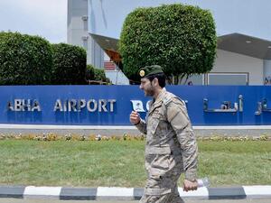 A Saudi serviceman walks by a sign outside Abha airport. (AFP)