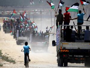Palestinian demonstrators wave their national flag as they drive towards the border fence with Israel, east of Gaza City on July 22, 2019. (MOHAMMED ABED / AFP)