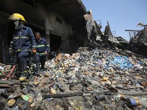 Iraqi firefighters inspect the charred remains of a warehouse in Baghdad's Sadr City on August 23, 2019, after a large fire broke out overnight. (AHMAD AL-RUBAYE / AFP)